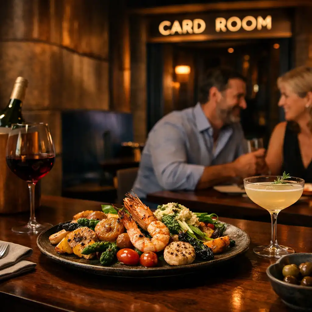 Guests finishing dinner with cocktails as the softly lit Card Room entrance sits beyond